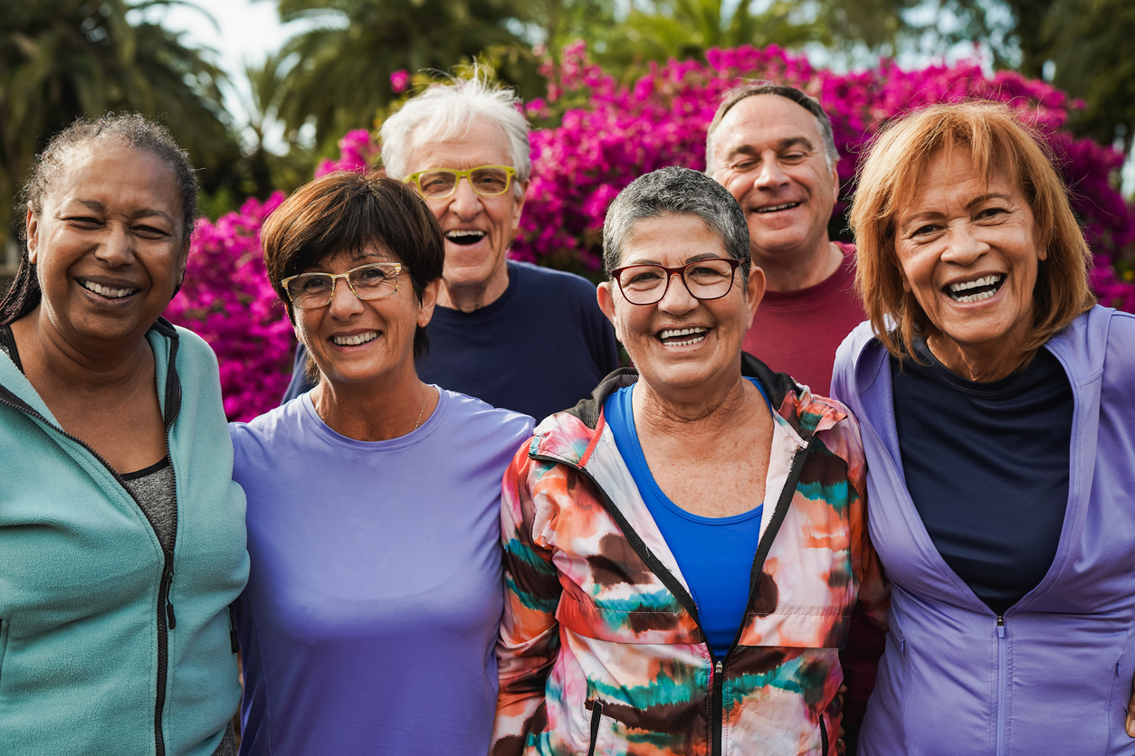 Group of senior friends smiling on camera after yoga lesson at city park Premier Senior Living in Olmsted County | AVIVA River Bend