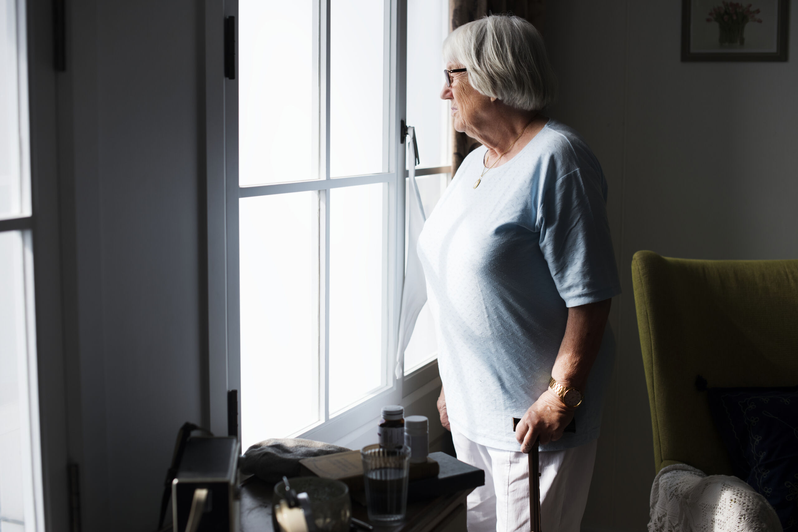 Lonely Senior Woman staring out a window